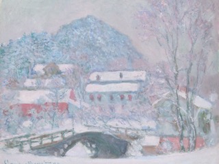 A snowy Norwegian village with red-roofed houses and a small bridge over a stream, beneath a snow-covered mountain.