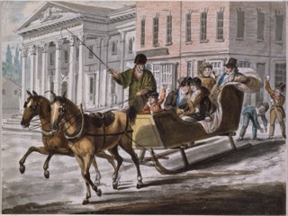 A family rides in a sleigh pulled by two horses past the columned front of the First Bank of the United States in the snow.